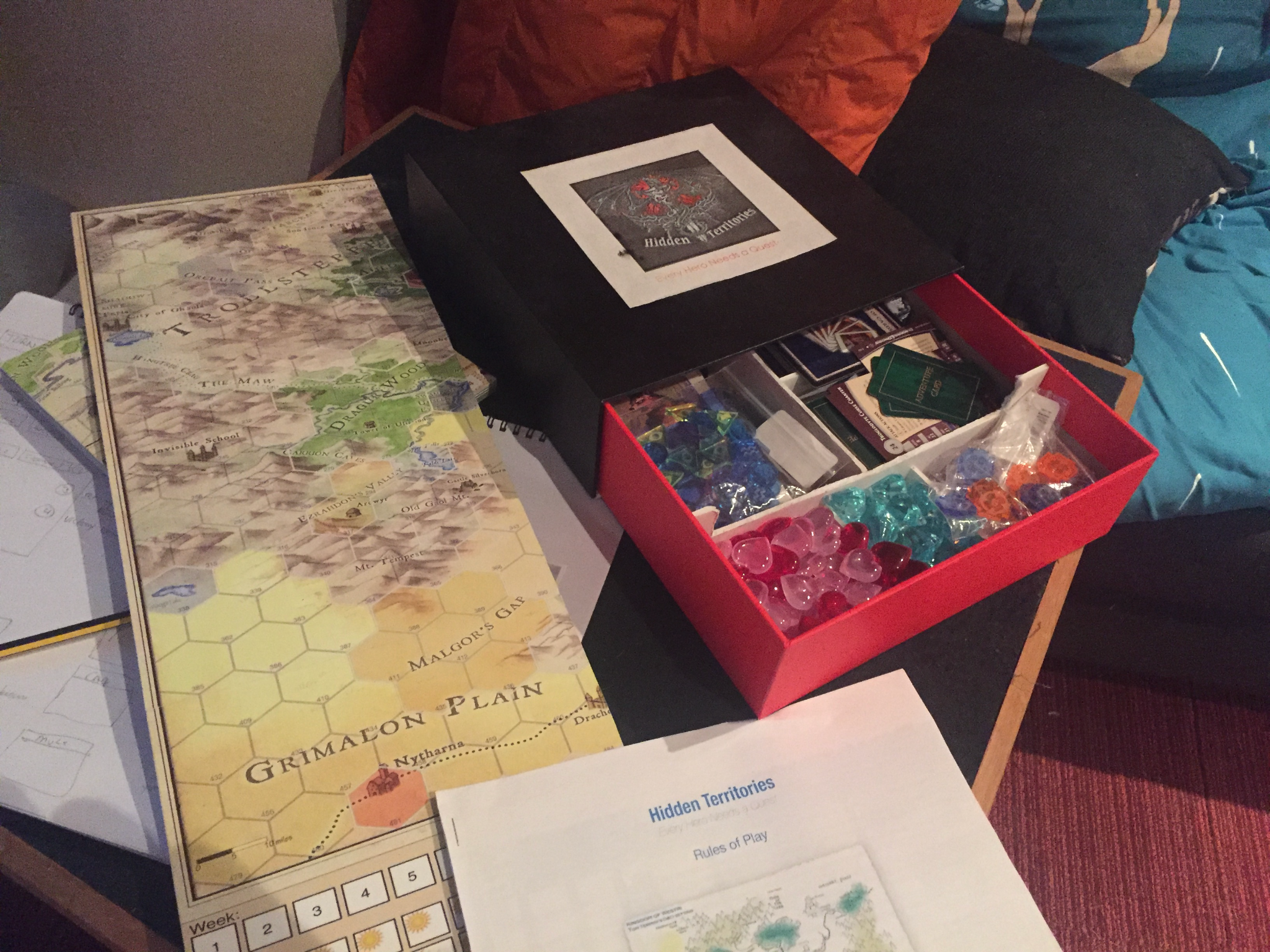 An early red-box prototype of The Hidden Territories beside the Westri map and rules pages.